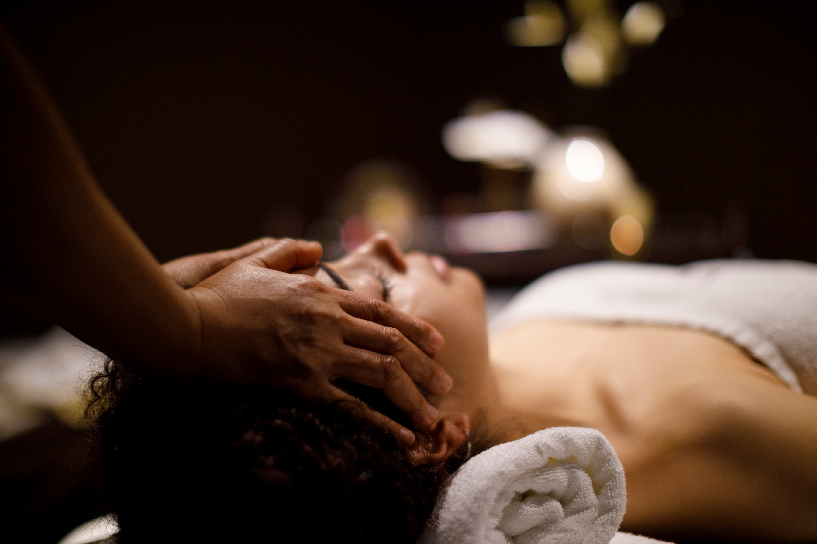 Woman enjoying head massage in spa center